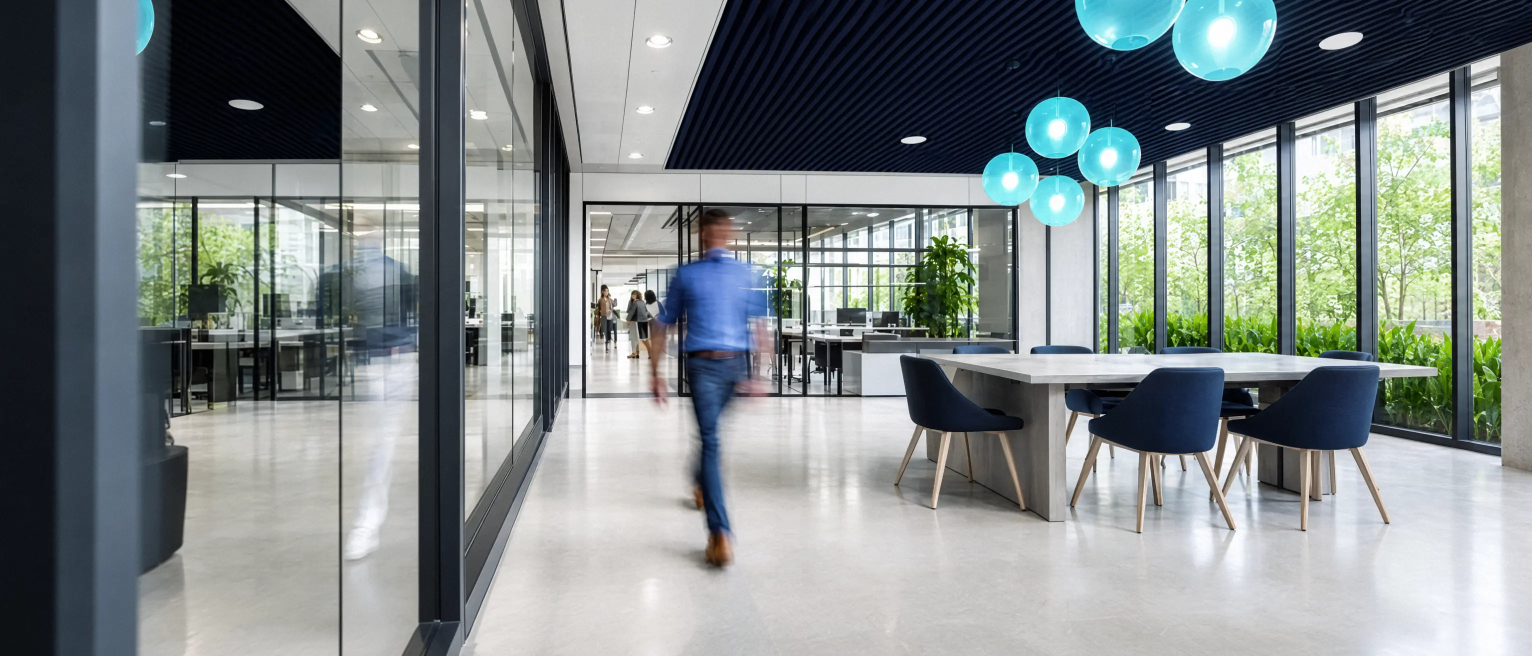 Des bureaux vitrés, une personne traverse l’espace de travail