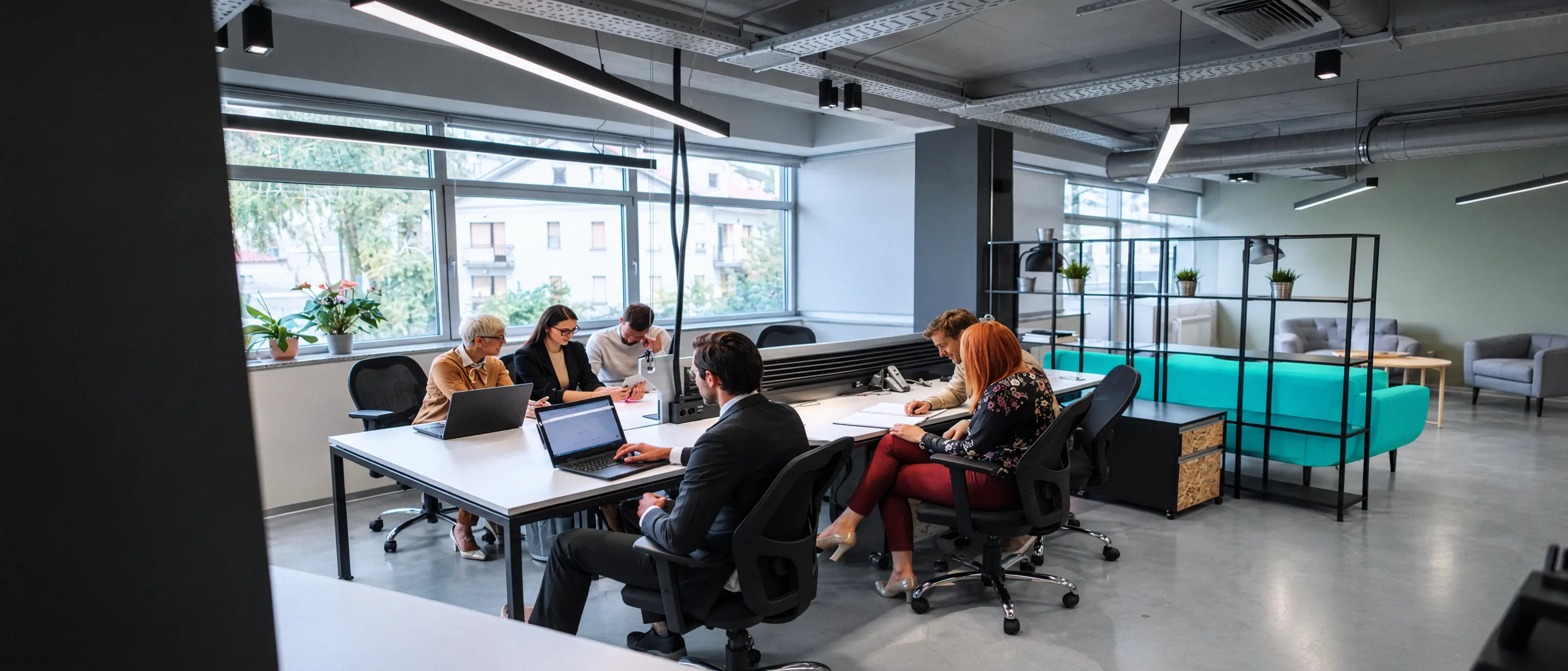Une équipe au travail autour d’une grande table, dans un bureau ouvert