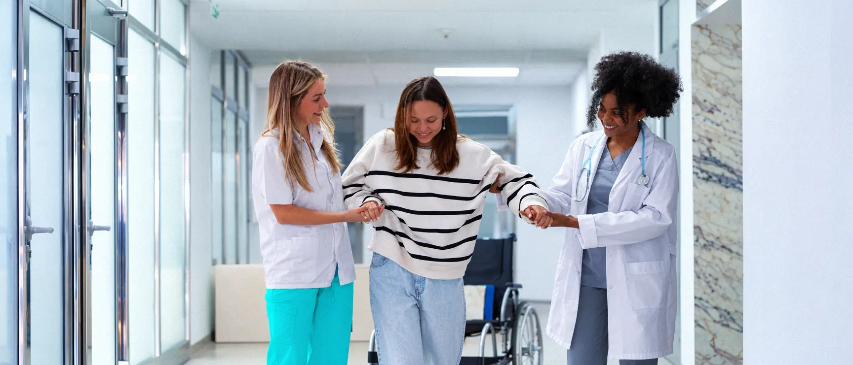 Des intervenantes accompagnent une personne dans un couloir