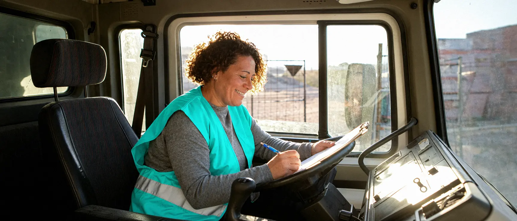 Une conductrice remplit un document dans la cabine de son camion