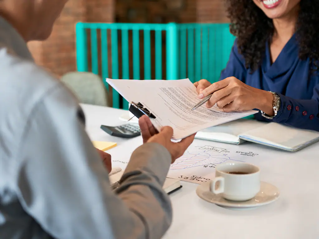 Une avocate et un client relisent un document au bureau