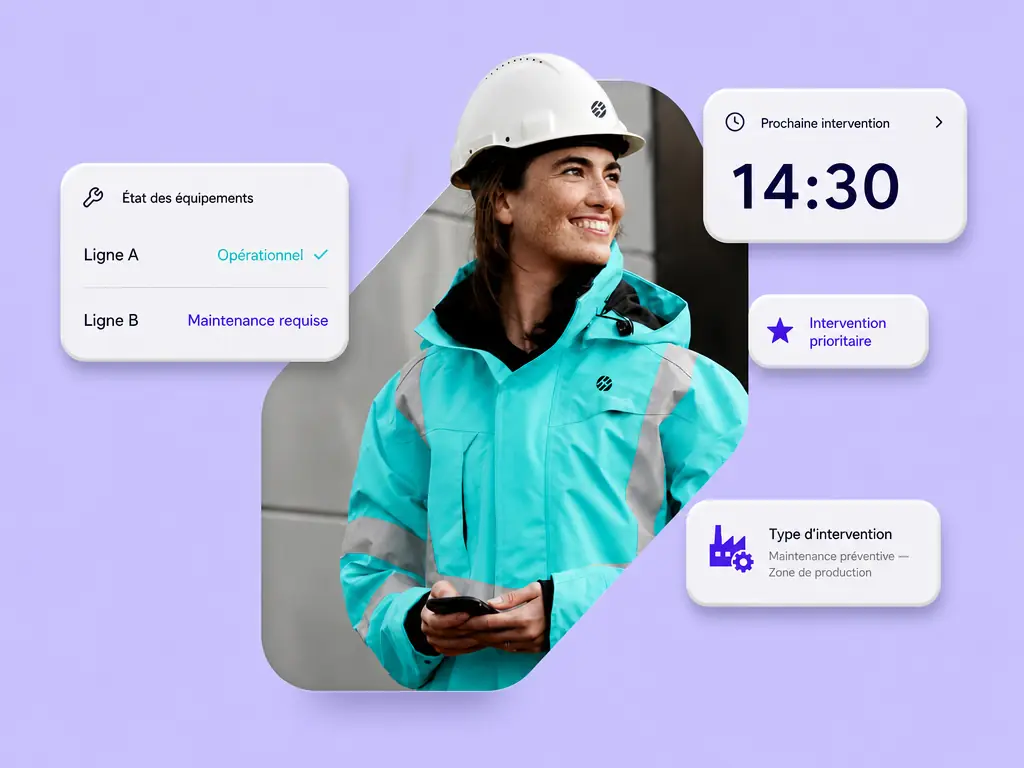 Une technicienne de maintenance en tenue de travail consulte son téléphone